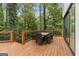 Spacious outdoor dining on wood deck with lush, wooded views, perfect for relaxing or entertaining at 1153 Dawn View Nw Ln, Atlanta, GA 30327