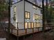 Modern home's exterior showcasing a large deck, multiple windows, and professional landscaping for enhanced curb appeal at 1153 Dawn View Nw Ln, Atlanta, GA 30327