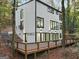 Modern home's exterior showcasing a large deck, multiple windows, and professional landscaping for enhanced curb appeal at 1153 Dawn View Nw Ln, Atlanta, GA 30327