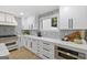 Stylish kitchen boasts white cabinets, marble backsplash, stainless steel appliances, and an oven built into the cabinets at 1153 Dawn View Nw Ln, Atlanta, GA 30327