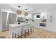 Bright kitchen featuring white cabinets, a marble backsplash, stainless steel appliances, and a large island with seating at 1153 Dawn View Nw Ln, Atlanta, GA 30327