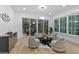 Comfortable seating in a living room with large windows and hardwood floors, with deck access and wooded views at 1153 Dawn View Nw Ln, Atlanta, GA 30327