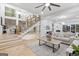Open-concept living room with hardwood floors, a staircase, a ceiling fan, and large windows overlooking a wooded area at 1153 Dawn View Nw Ln, Atlanta, GA 30327