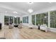 Open living room featuring hardwood floors, large windows with tree views, and comfortable seating arrangements at 1153 Dawn View Nw Ln, Atlanta, GA 30327