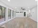 Open-concept living room with wall-to-wall windows, ceiling fan, and access to the deck at 1153 Dawn View Nw Ln, Atlanta, GA 30327