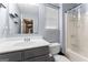 Neutral bathroom featuring a tub with shower, window, and sink with storage underneath at 308 Dylan Way, Mcdonough, GA 30252
