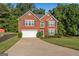 Traditional brick home with a two-car garage, well-manicured lawn, and mature landscaping at 440 Homeplace Dr, Stockbridge, GA 30281