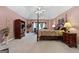 Spacious primary bedroom with a large four-poster bed, sitting area and neutral carpet at 440 Homeplace Dr, Stockbridge, GA 30281