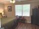 Bedroom featuring a king-size bed, wood flooring, neutral walls, and natural light at 60 Carriage Gate Dr, Sharpsburg, GA 30277