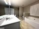 Bright bathroom with double vanity, soaking tub, shower, and natural light at 7963 Smith Rd, Villa Rica, GA 30180