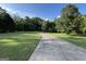 A long driveway leads up to a picturesque property, framed by manicured lawns and mature trees at 7963 Smith Rd, Villa Rica, GA 30180