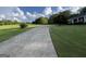 Long driveway leading to a home on a lush, green lawn underneath a beautiful sky at 7963 Smith Rd, Villa Rica, GA 30180