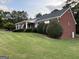 Charming red brick home with a covered porch and well-kept landscaping at 7963 Smith Rd, Villa Rica, GA 30180