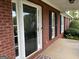Exterior view of a red brick house with an open front porch and lush green landscaping at 7963 Smith Rd, Villa Rica, GA 30180