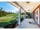 Spacious covered porch, enhanced by lush landscaping and verdant lawn in the background at 7963 Smith Rd, Villa Rica, GA 30180