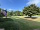A manicured front yard, blue sky, and an American flag waving from the porch of the house at 7963 Smith Rd, Villa Rica, GA 30180