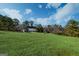 Expansive green lawn surrounds this brick home, enhanced by mature trees and landscaping at 7963 Smith Rd, Villa Rica, GA 30180