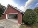 Spacious brick garage with an open door and well-maintained landscaping at 7963 Smith Rd, Villa Rica, GA 30180