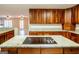 Kitchen featuring granite countertops and a cooktop island with hardwood floors and wood cabinets at 7963 Smith Rd, Villa Rica, GA 30180