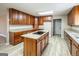 Modern kitchen with granite countertops, wood cabinets and an island with a cooktop at 7963 Smith Rd, Villa Rica, GA 30180