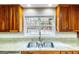 Bright kitchen with a stainless steel sink and wooden cabinets, complemented by granite countertops and a backyard view at 7963 Smith Rd, Villa Rica, GA 30180