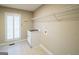 Bright laundry room with a utility sink, storage shelves, and tiled floor at 7963 Smith Rd, Villa Rica, GA 30180