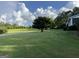 Expansive front yard with lush green lawn, mature trees, and clear blue sky at 7963 Smith Rd, Villa Rica, GA 30180