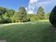 Spacious front yard with lush green lawn and mature trees on a sunny day at 7963 Smith Rd, Villa Rica, GA 30180
