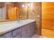 Bathroom featuring wood-paneled walls and a modern vanity with quartz countertops, exuding rustic charm and contemporary elegance at 1597 Leguin Mill Rd, Locust Grove, GA 30248