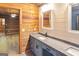 A bathroom featuring a granite countertop, gray cabinets with wooden accents, and a spacious sink area at 1597 Leguin Mill Rd, Locust Grove, GA 30248