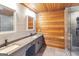 This bathroom features a walk-in shower, dual sinks, gray cabinets, and wooden walls and accents at 1597 Leguin Mill Rd, Locust Grove, GA 30248