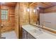 Bathroom featuring wood-paneled walls, a modern vanity, and marble-look flooring, exuding rustic charm and contemporary elegance at 1597 Leguin Mill Rd, Locust Grove, GA 30248