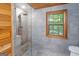 This bathroom has a walk-in shower, modern fixtures, and a large window with a scenic outdoor view at 1597 Leguin Mill Rd, Locust Grove, GA 30248