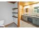 The bathroom features floating wooden shelves, modern vanity, and dual mirrors and sinks at 1597 Leguin Mill Rd, Locust Grove, GA 30248