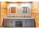A well-lit bathroom features dual sinks, granite countertop and gray cabinets with wooden accents at 1597 Leguin Mill Rd, Locust Grove, GA 30248