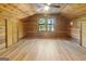 Bedroom featuring wood-paneled walls and ceilings and wood-look flooring, creating a cozy and rustic retreat at 1597 Leguin Mill Rd, Locust Grove, GA 30248