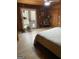 Bedroom with wood-paneled walls and ceilings with access to a deck with nature views creating a cozy and serene retreat at 1597 Leguin Mill Rd, Locust Grove, GA 30248