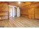This bedroom features wood walls, wood-look flooring, and an ample closet with a louvred door at 1597 Leguin Mill Rd, Locust Grove, GA 30248