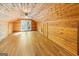 Bonus room featuring wood-paneled walls and ceilings and wood-look flooring with access to a balcony with nature views at 1597 Leguin Mill Rd, Locust Grove, GA 30248