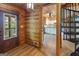 Inviting foyer featuring wood paneling, stylish flooring, and a view into the kitchen with a spiral staircase at 1597 Leguin Mill Rd, Locust Grove, GA 30248