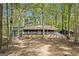 Charming ranch-style home surrounded by lush trees and a covered front porch, providing a serene curb appeal at 1597 Leguin Mill Rd, Locust Grove, GA 30248