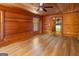 An inviting living room with wood walls, a ceiling fan, and large windows that provides plenty of natural light at 1597 Leguin Mill Rd, Locust Grove, GA 30248