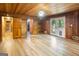 A bright living room featuring wood walls, light floors, and glass doors leading to the outside at 1597 Leguin Mill Rd, Locust Grove, GA 30248