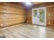 This cozy living room features wood walls, light floors, and glass doors leading to the outdoor area at 1597 Leguin Mill Rd, Locust Grove, GA 30248