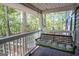 Relax on this porch swing with padded cushions, overlooking the serene woods at 1597 Leguin Mill Rd, Locust Grove, GA 30248
