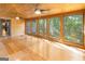 Light-filled sunroom with wood-paneled walls, scenic views, and hardwood floors at 1597 Leguin Mill Rd, Locust Grove, GA 30248