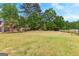 Spacious backyard with lush green grass, mature trees, and a well-maintained fence, perfect for outdoor activities at 317 Calgary Dr, Peachtree City, GA 30269