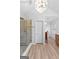Bright bathroom showcasing a glass shower, stylish chandelier, wood-look flooring, and modern fixtures with walk in closet at 317 Calgary Dr, Peachtree City, GA 30269
