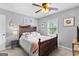 Cozy bedroom featuring wood-frame bed, ceiling fan, and ample natural light from the bright, sunlit window at 317 Calgary Dr, Peachtree City, GA 30269