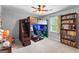 Cozy bedroom with a loft bed, desk, and bookshelf filled with books, and a ceiling fan at 317 Calgary Dr, Peachtree City, GA 30269